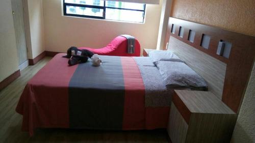 un dormitorio con una cama con un animal de peluche en Hotel H Uno 77 Adults Only, en Ciudad de México