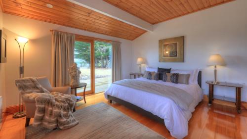 a bedroom with a bed and a chair and a window at The Peninsula Experience in Dover