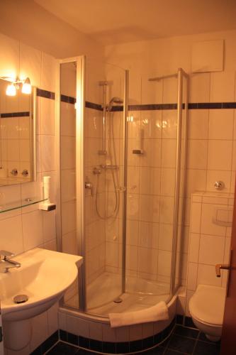 a bathroom with a shower and a sink at Hotel Spiekeroog in Spiekeroog