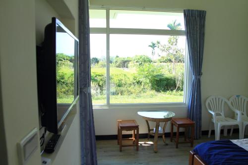 ein Schlafzimmer mit einem großen Fenster sowie einem Tisch und Stühlen in der Unterkunft Meet Canaan in Xikou