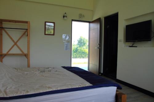 a bedroom with a bed and a flat screen tv at Meet Canaan in Xikou
