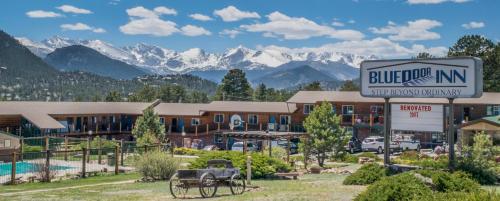 a hotel with a sign and mountains in the background at Blue Door Inn in Estes Park