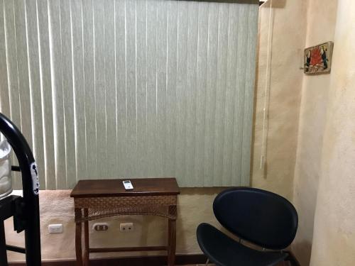 a room with a desk and a chair and a table at La Palapa Hut Nature Hostel in Puerto Jiménez