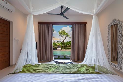 a bedroom with a canopy bed with a view of a pool at Alosta Luxury Private Villa in Ubud