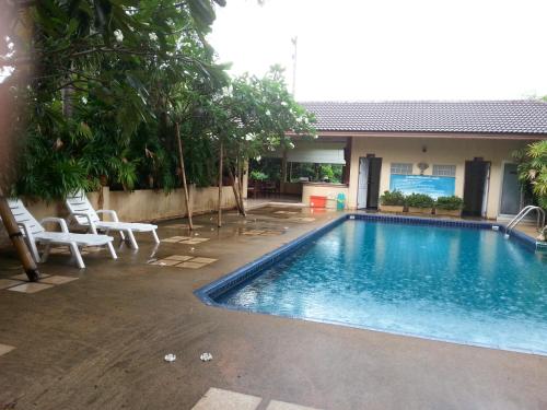 a swimming pool with chairs and a house at C.A.P Mansion in Phuket Town