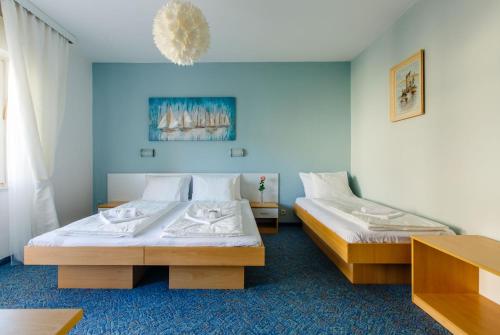 two beds in a room with blue walls at Rooms Split in Split