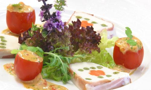 a plate of food with a salad and tomatoes at Hotel Vivendi in Herford