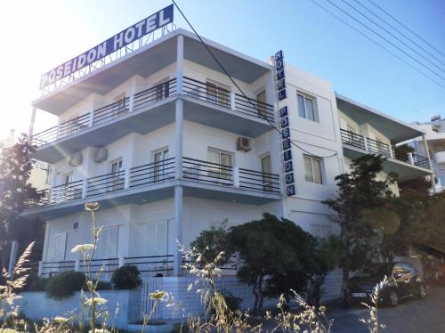 a white building with a sign on it at Poseidon Hotel in Heraklio Town