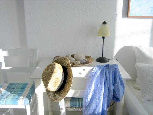 a white table with a hat on top of it at Studios Anemomilos in Astypalaia Town