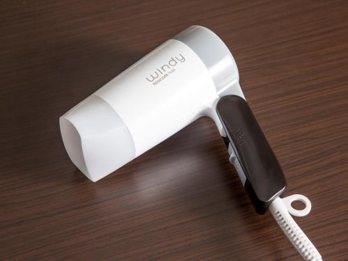 a white electric hair drier on a wooden table at APA Hotel Mito-Ekimae in Mito