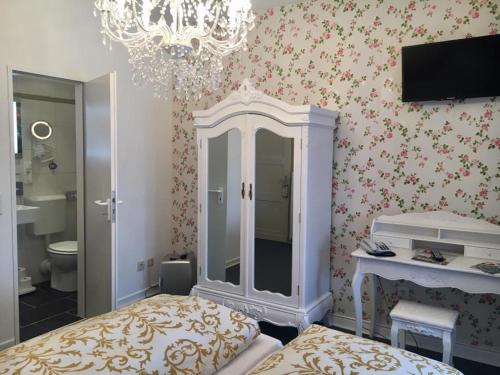 a bedroom with a bed and a chandelier at Kurvilla Fürstin Pauline in Bad Salzuflen