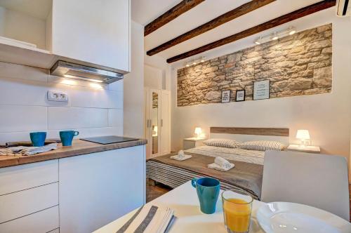 a kitchen and a bedroom with a bed in a room at Apartman Amfiteatar Franko in Pula