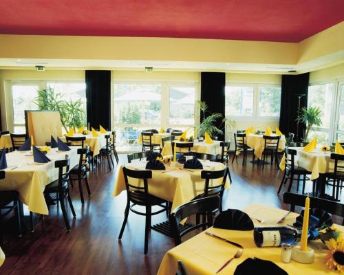 a restaurant with tables and chairs with yellow tablecloths at Ara Classic in Ingolstadt