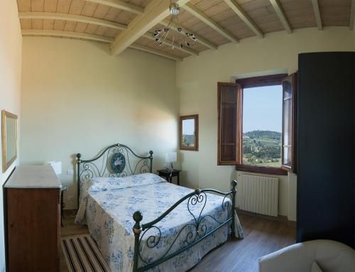 a bedroom with a bed and a large window at Il balcone di Rina in San Gimignano