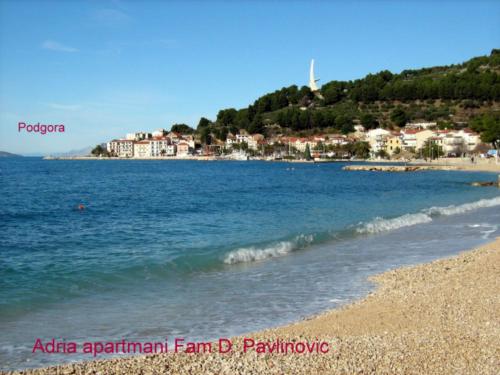 a view of a beach with a town in the background at Adria Apartments in Podgora
