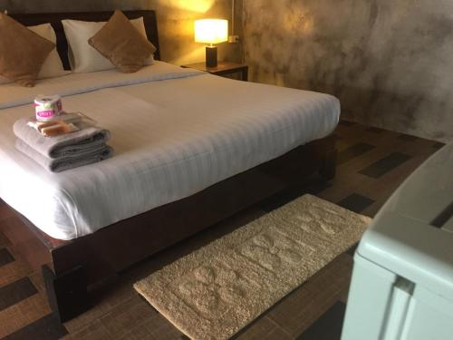 a bedroom with a bed with a pile of towels at Crescent Bay Resort in Ko Samed
