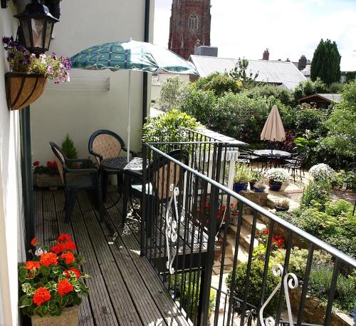 a balcony with a table and chairs and an umbrella at The Little Elbow Room in Totnes