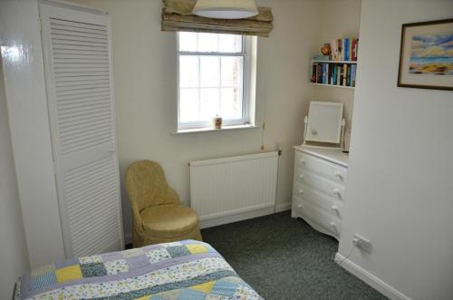 sypialnia z łóżkiem, komodą i oknem w obiekcie The Little Elbow Room w mieście Totnes