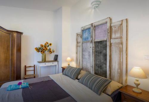ポルト・サン・パーオロにあるLe Case del Mareのベッドルーム1室(大型ベッド1台、木製ヘッドボード付)