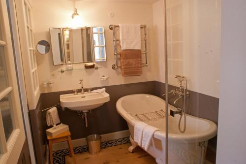a bathroom with a tub and a sink and a bath tub at Hôtel Bella Tola & SPA in Saint-Luc