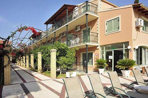 un grupo de sillas sentadas frente a un edificio en Philippos Kassiopi Apartments en Kassiopi