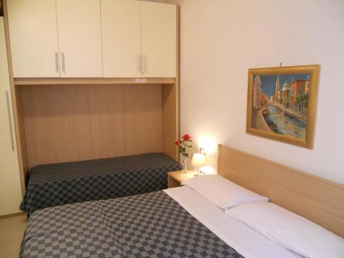 ヴェネツィアにあるCorte Lucatellaのベッドルーム1室(ベッド2台付)が備わります。壁には絵画が飾られています。