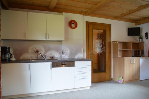 a kitchen with white cabinets and a refrigerator at Haus Lorenz in Grän