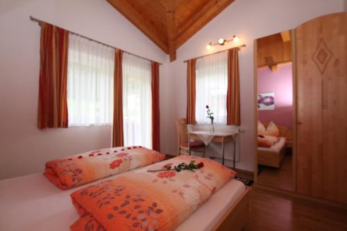 ein Schlafzimmer mit einem Bett und einem Tisch in einem Zimmer in der Unterkunft Haus Gugglberger in Hainzenberg