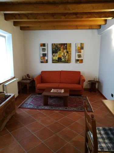 a living room with a red couch and a table at Ciasa Cimoliana in Cimolais