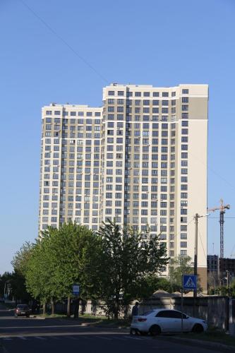 a white car parked in front of a large building at Solo Apartment Virmenska in Kyiv