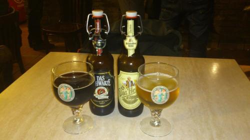 two bottles of beer sitting on a table with two glasses at Casa Rural Celtia in Aguilar del Río Alhama