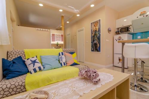 a living room with a yellow couch in a room at Beachfront House with Private Jacuzzi and Garden Zadar in Zadar