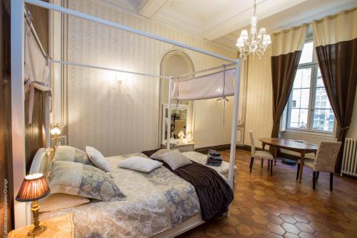 a bedroom with a bed and a table and a dining room at La Petite Saunerie in Avignon