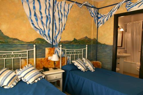 プリエゴ・デ・コルドバにあるHotel Las Rosasのベッドルーム1室(ベッド2台付)が備わります。壁には絵画が飾られています。