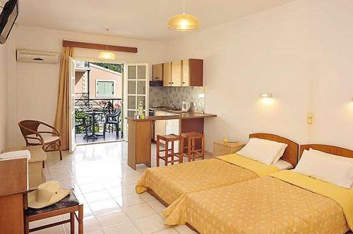 ein Hotelzimmer mit 2 Betten und einer Küche in der Unterkunft Philippos Kassiopi Apartments in Kassiopi