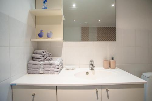 a bathroom with a sink and a mirror and towels at Tiigi Villa in Haapsalu