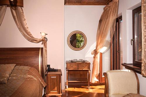 a bedroom with a bed and a table and a mirror at Archontiko Koilia in Makrinítsa
