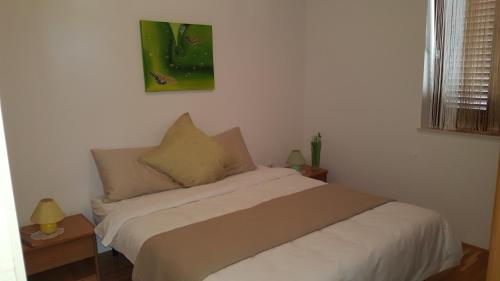 una camera con un letto e una foto appesa al muro di VILLAMAR beachfront apartments with FREE private parking a Rabac