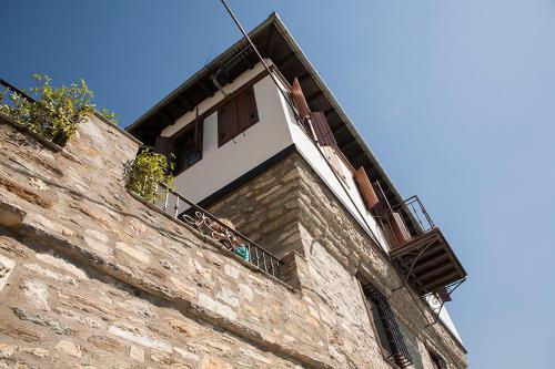 a brick building with a window and a balcony at Archontiko Koilia in Makrinítsa