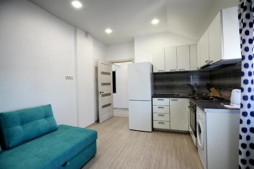 una cucina con divano blu in una camera di Apartment Zolotoy Bereg 5 a Odessa