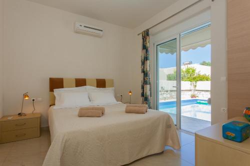Villa Nopigia Somina في كيساموس: غرفة نوم مع سرير مع إطلالة على المسبح