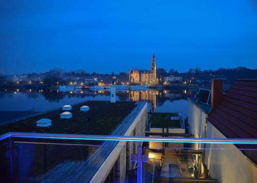 a view of a river at night with a city at Ringelnatz Inselhotel in Malchow