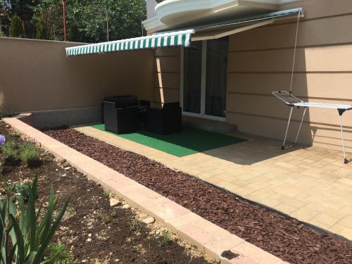 a patio with a green lawn in front of a house at Villa Mona Lisa in Hévíz