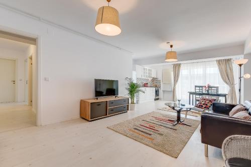 a living room with a couch and a tv at Bucharest Airport Suites & Villas in Otopeni