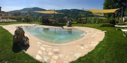 a pool with rocks in the middle of a yard at Locanda Montelippo in Colbordolo