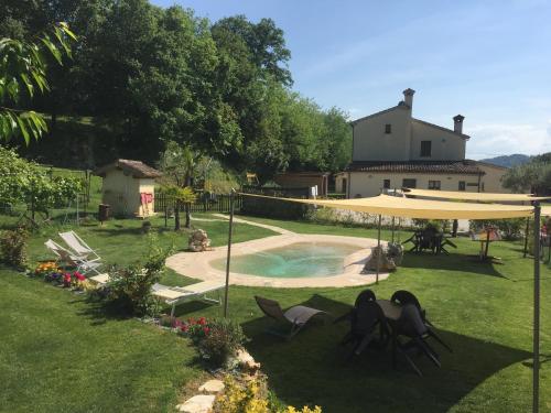 a backyard with a pool and a yellow umbrella at Locanda Montelippo in Colbordolo