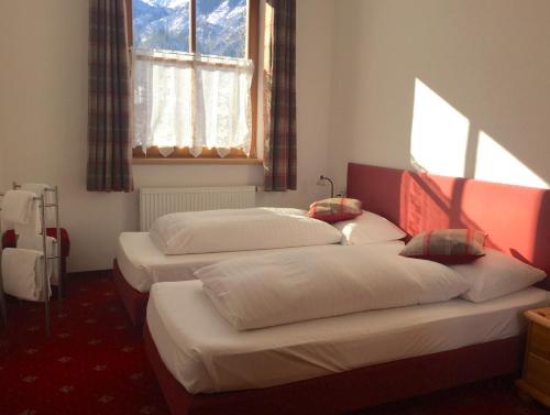 3 łóżka w pokoju z oknem w obiekcie Kitz Residenz Top 6 w Kaprunie