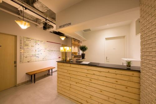 a room with a wooden floor and a wall with a clock on it at Grids Sapporo Hotel&Hostel in Sapporo