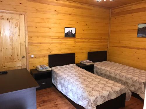 2 camas en una habitación con paredes de madera en Отель Гудоу, en Gudauta
