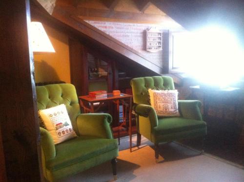 two green chairs and a table in a room at Casa Solallosa 112 in Quijas